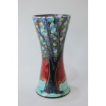 A Carlton Ware porcelain vase, a trial piece by Anita Harris depicting a blue tree on red ground,