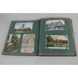 A late Victorian postcard album including black and white and colour photographic postcards