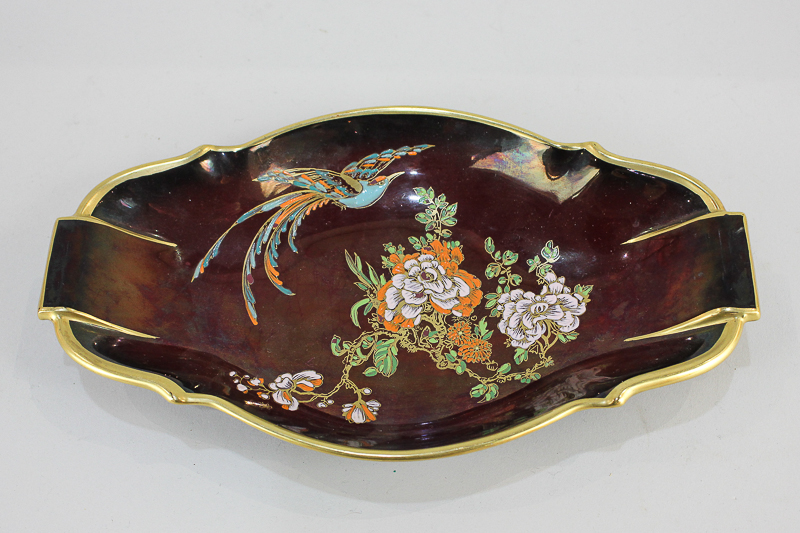A Carltonware porcelain dish depicting a bird of paradise and flowering tree on Rouge Royale ground,