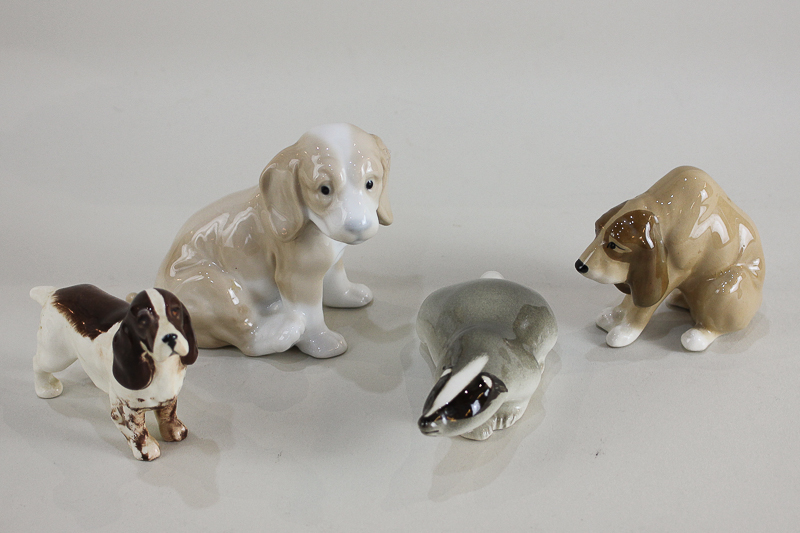 A Beswick model of a spaniel, a Szeiler model of a hound, a John Buck model of a dog, and a