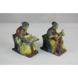 A pair of 19th century pottery figures, possibly German, of two seated women, one with needlework,