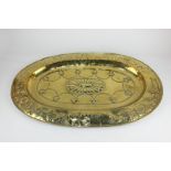 A 19th century brass oval embossed platter depicting a shooting scene, 61cm wide