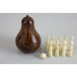 A treen pear shaped box containing a set of nine miniature bone skittles and ball