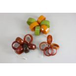 A collection of seventeen bakelite and plastic napkin rings in shades of amber, orange and green