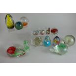 A collection of fourteen glass paperweights, various shapes and designs, to include five in the form