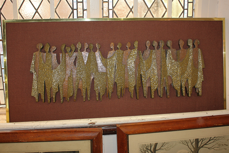 A mid 20th century composition wall relief of a line of abstracted figures in two-tone textured