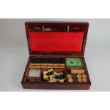 An early 20th century games compendium in mahogany box, comprising game boards, dominoes, whist,