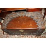 A Chinese carved camphor wood coffer decorated with flowers and foliage, with brass lock and key,