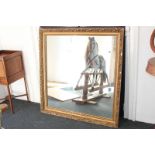 A gilt and gesso rectangular wall mirror with bevelled scroll and bead decorated frame, glass 95cm