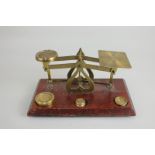 A set of brass postal scales with three weights