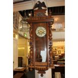 A Vienna style walnut wall clock with 7 inch dial, Roman numerals, and eagle surmount