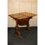 A Victorian walnut games/work table with rising serpentine top enclosing inlaid chess and backgammon