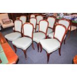 A set of ten mahogany framed balloon back dining chairs with green silk upholstered padded backs and
