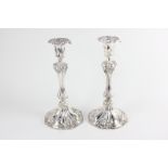 A pair of Victorian silver candlesticks with embossed leaf and scroll design, 26cm high, maker