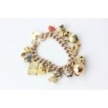 A 9ct gold curb link bracelet hung with various charms 59.9g gross