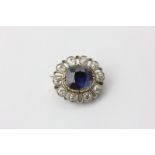 A sapphire and diamond brooch, the oval cut stone multi-claw set in a border of ten old cut