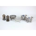 A George V silver six piece cruet set, oval form with pierced decoration, on claw and ball feet (two