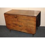 A 19th century mahogany drop-leaf dining table on turned legs and castors, 157cm fully extended