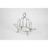 An Edward VII silver toast rack with hoop handle and shaped base on four feet, maker Walker and