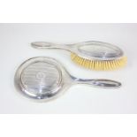 A George V silver matching dressing table hand mirror and brush, with engraved initials,