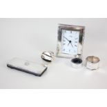 A modern silver framed travel clock, a silver topped pocket calculator, two napkin rings, one with