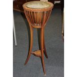 An Edwardian inlaid mahogany jardiniere stand with slatted drum top and copper planter, on three