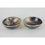 A pair of polished horn bowls with white metal rims, 12cm diameter