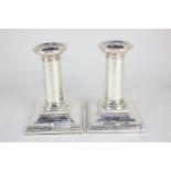 A pair of Victorian silver dwarf candlesticks with detachable nozzles, column stems on stepped