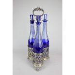 A silver plated three-bottle cruet stand with pierced design and scroll handle, the three cut