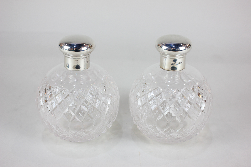 A pair of George V silver mounted cut glass scent bottles, maker H W, London 1922