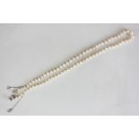 A single row pearl necklace, the graduated beads strung and knotted on a millegrain set old cut