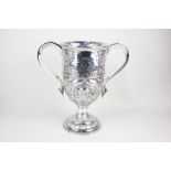 A late Victorian large silver trophy cup, twin scroll handled with deeply embossed floral