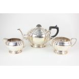 A George VI silver three piece tea set, oval form with fluted corners, on pedestal foot, maker