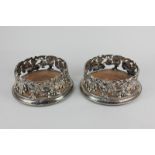 A pair of silver plated bottle coasters with pierced grape vine design, 13cm internal diameter