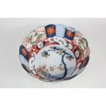 A Japanese Imari porcelain bowl of scalloped form, depicting a riverside and panels of pomegranates,