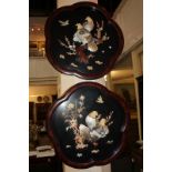 A pair of Japanese black lacquered wall panels of scalloped form, each with applied decoration of
