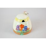 A Clarice Cliff, Newport Pottery, honey pot and cover in the Iris pattern, 10cm high