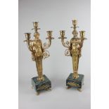 A pair of Regency style gilt metal three-light candelabra with female figure holding aloft branches,
