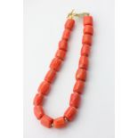 A coral necklace strung with cylindrical beads on a gilt clasp