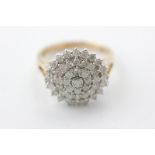 A diamond cluster ring, the domed table claw set with split shoulders, stated diamond weight 1