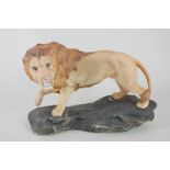 A Beswick porcelain model of a lion on rock (model 2554A), part of the Connoisseur series, in golden
