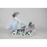 A Lladro porcelain figure group of a girl holding the leads of two dogs surrounded with five