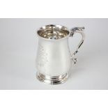 A George III silver mug, baluster shape on circular foot with leaf capped scroll handle, with