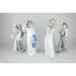 Two Nao porcelain figures of children in nightdresses, 29cm, and a Lladro figure of a boy with