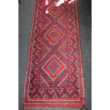 A Turkish wool runner rug with red, blue and white geometric design 67cm by 276cm