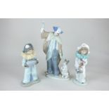 A Nao porcelain figure of a clown and puppy, 29cm, and two figures of children dressed as clowns,