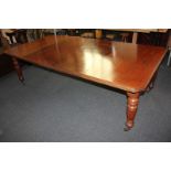 An Edwardian mahogany extending dining table, rectangular top with canted corners, with two extra