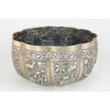 A Chinese white metal fruit bowl of lobed form, decorated with panels of animals and figures amongst