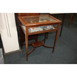 An Edwardian inlaid mahogany vitrine with rectangular glazed rising top and glazed sides, on