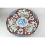 A Chinese porcelain charger with central blue and white design of a figure in a boat, the three-